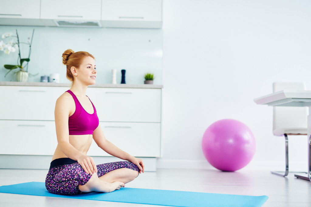 red haired woman doing yoga exercises at home