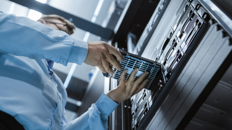 it personnel putting back a backup drive in a server