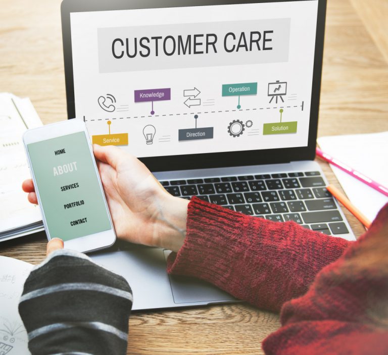 a female entrepreneur holding a phone and laptop with customer care