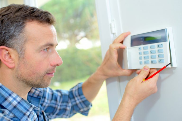 man installing home security system