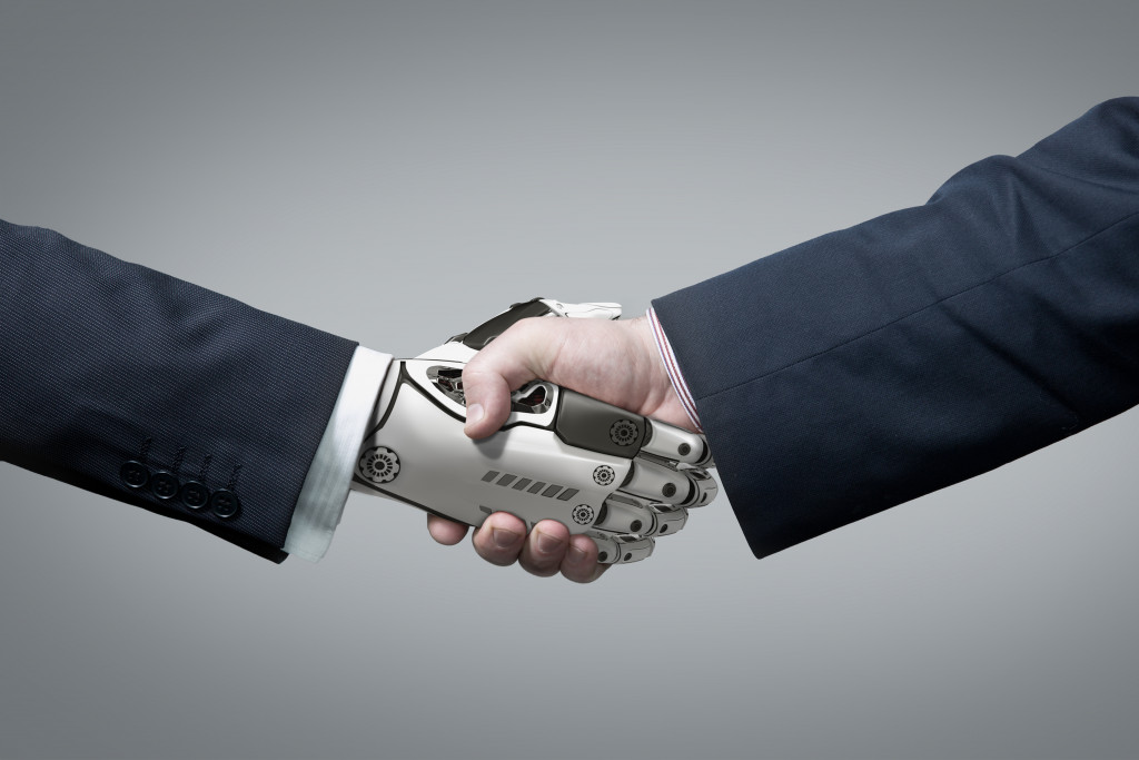 human and robot hands in handshake